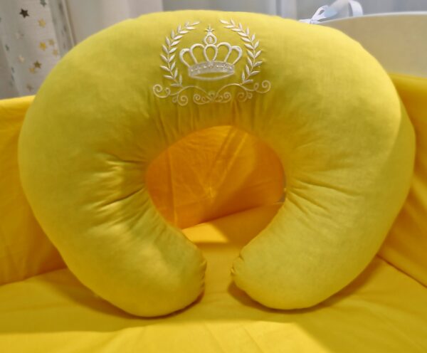 Almofada de amamentação amarela com coroa bordada